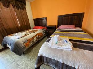two beds in a room with two beds sidx sidx sidx at Hotel del Ferrocarril in Quetzaltenango