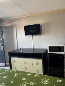 a room with a dresser with a tv on the wall at EDGEBROOK MOTEL in Chicago