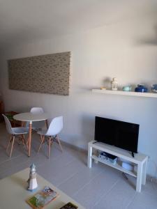 sala de estar con TV y mesa en Las Islas Apartment en Corralejo