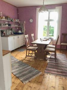 jadalnia ze stołem i krzesłami oraz oknem w obiekcie Lakeside Guesthouse w mieście Ramvik