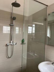 y baño con ducha y lavamanos. en WellingManor Apartments - Luxury, en Accra