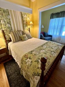 a bedroom with a bed with a floral bedspread at Red Rocker Inn in Black Mountain