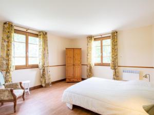 LanouailleにあるMaison spacieuse avec piscine privée, wifi et parking à Lanouaille - FR-1-616-335のベッドルーム1室(ベッド1台、椅子、窓付)