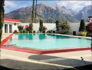 a large swimming pool with mountains in the background at Hotel Asia Vaishnodevi in Katra