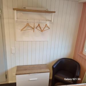 a room with a chair and a desk and hangers at Mountain - Lake Apartment 3 in Wilderswil