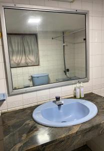 a bathroom sink with a large mirror above it at MercuryFM 103 Guest House - Colombo 3 in Colombo