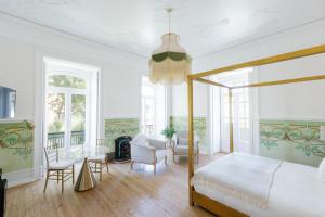 Schlafzimmer mit einem Bett, einem Tisch und Stühlen in der Unterkunft Palácio do Visconde - The Coffee Experience in Lissabon