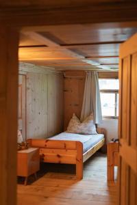 a small bedroom with a bed with a canopy at Great old WÄLDERHAUS in Au im Bregenzerwald