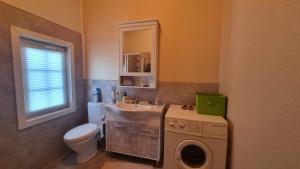 a bathroom with a sink and a washing machine at Summer cottage in Jurmala in Jūrmala