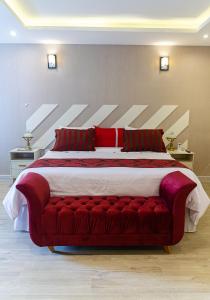 Pousada Granja Santa Barbara في بتروبوليس: غرفة نوم بسرير كبير ومخدات حمراء