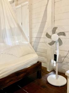 a bedroom with a fan next to a bed at Cabanas ecoturisticas Costa Maya in Mahahual