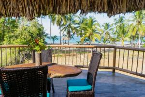 a wooden table and chairs on a deck with the beach at UUTTAAKA Eco-Hotel in Palomino