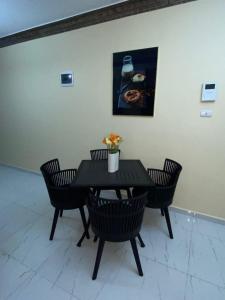 une table noire avec des chaises et une photo sur le mur dans l'établissement Acogedor Apartamento, à Santiago de los Caballeros