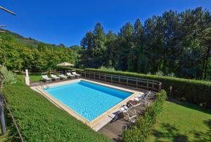 a swimming pool in a yard with lounge chairs at Villa Casale Di Rosa in Lucca