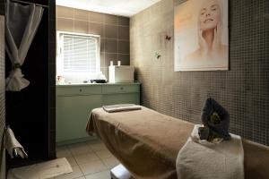 a bathroom with a bed and a tub and a sink at Résidence Thermotel in Bourbonne-les-Bains