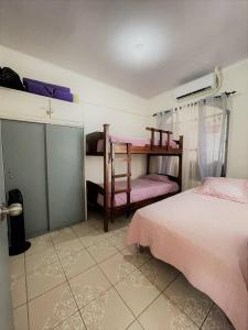 a bedroom with two beds with pink sheets at Relax at Pier Sands Casita#1 - Close to the Beach! in Puntarenas