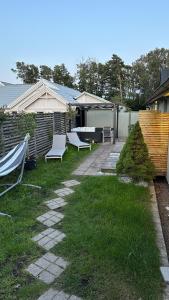a yard with two white chairs and a fence at Strandviks semesterboende in Halmstad