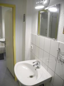 ein Badezimmer mit einem weißen Waschbecken und einem Spiegel in der Unterkunft Flow Home in Berlin
