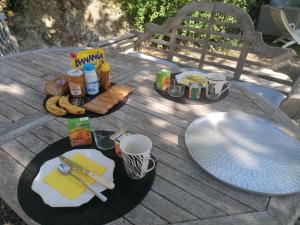 una mesa de picnic con comida y bebidas. en Hacienda chambre avec petit déjeuner inclus, en Patrimonio