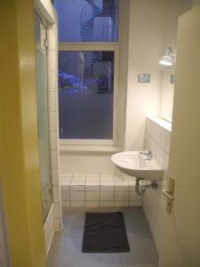 ein Bad mit einem Waschbecken und einem Fenster in der Unterkunft Flow Home in Berlin