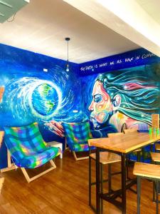 um mural num restaurante com cadeiras e uma mesa em See Sea Backpackers House em Ban Tai