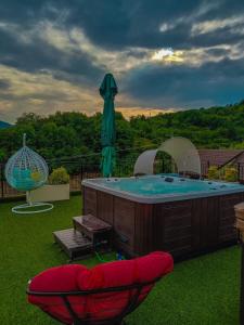 bañera de hidromasaje en un patio con sombrilla en Complex Turistic Cetatea Drencova 
