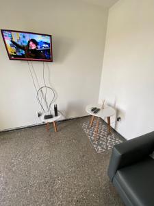 sala de estar con sofá y TV en la pared en Departamento en la Ciudad de Mendoza en Mendoza