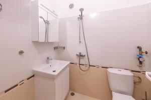 a white bathroom with a toilet and a sink at Perfect Spot Apartment in Varna City +21 photos
