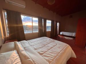 een slaapkamer met een groot bed voor een raam bij Avista al Rio in Puerto Iguazú