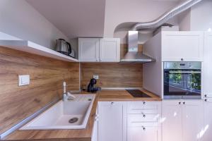 a kitchen with white cabinets and a sink at Perfect Spot Apartment in Varna City