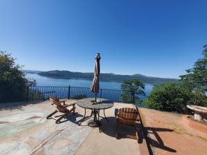 a patio with a table and chairs and an umbrella at A lake, a mountain and the house with the red door in Clearlake