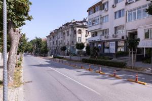 an empty street with orange cones on the side of a building at Perfect Spot Apartment in Varna City