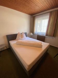 a bedroom with a large white bed with a window at Gasthof Seiser in Straßburg in Kärnten