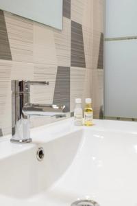 - un lavabo dans la salle de bains avec 2 bouteilles de savon dans l'établissement Albufeira BeachFront RC, à Albufeira