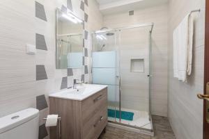La salle de bains est pourvue d'un lavabo et d'une douche en verre. dans l'établissement Albufeira BeachFront RC, à Albufeira