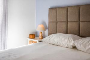 - une chambre dotée d'un lit blanc avec une tête de lit et une lampe dans l'établissement Albufeira BeachFront RC, à Albufeira