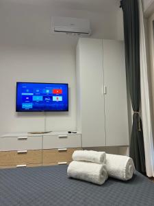 a living room with a tv and white cabinets at Tropical house in Lecce