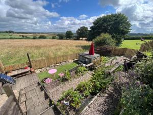 a garden with a red item on top of a house at Hardwick View Lodge in Holmewood