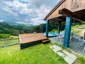 a house with a deck and a swimming pool at Villat Bardhoshi in Mitrovicë