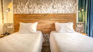 two beds sitting next to each other in a room at Hotel Bankir Khiva in Khiva