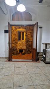 une porte ouverte menant à une pièce avec un mur en pierre. dans l'établissement Chez Taii, à Serralta