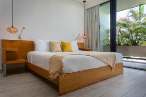 een slaapkamer met een groot bed en een groot raam bij Opal Suites Apartments in Playa del Carmen