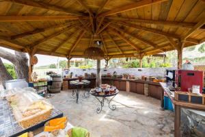 an outdoor kitchen with a large wooden roof at Aral Tatil Ciftligi in Bozcaada