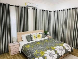 a bedroom with a bed and some curtains at Luxury WellingManor Apartment in Accra