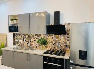 a kitchen with a sink and a stove at Luxury WellingManor Apartment in Accra
