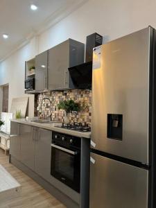 a kitchen with a stainless steel refrigerator and stove at Luxury WellingManor Apartment in Accra