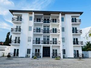 a white building with black balconies on it at Luxury WellingManor Apartment in Accra