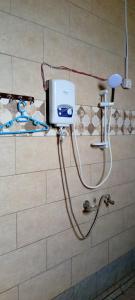 eine Dusche im Bad mit einem Seifenspender in der Unterkunft BIZI HOMES, KABUGA 