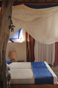 a bedroom with a bed with a mosquito net at Mango Island Lodges in Saint Joseph
