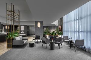 un vestíbulo con sillas, mesas y plantas en Melbourne Marriott Hotel, en Melbourne